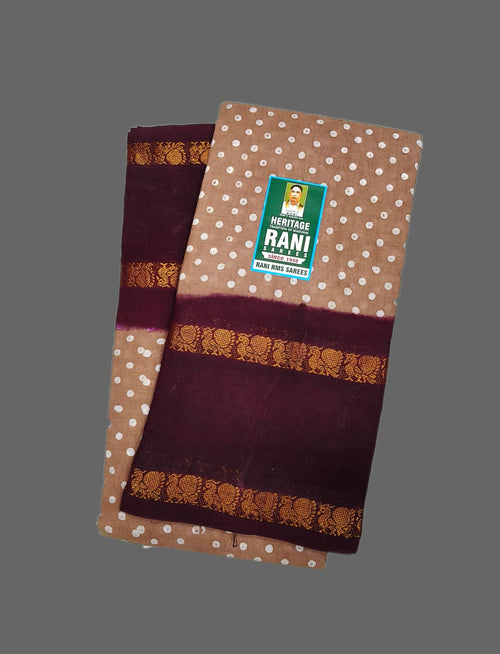 A folded Heritage Rani Handloom cotton fabric piece, likely a sari, in brown with white polka dots, deep maroon borders, and gold zari motifs, displayed on a solid gray background.